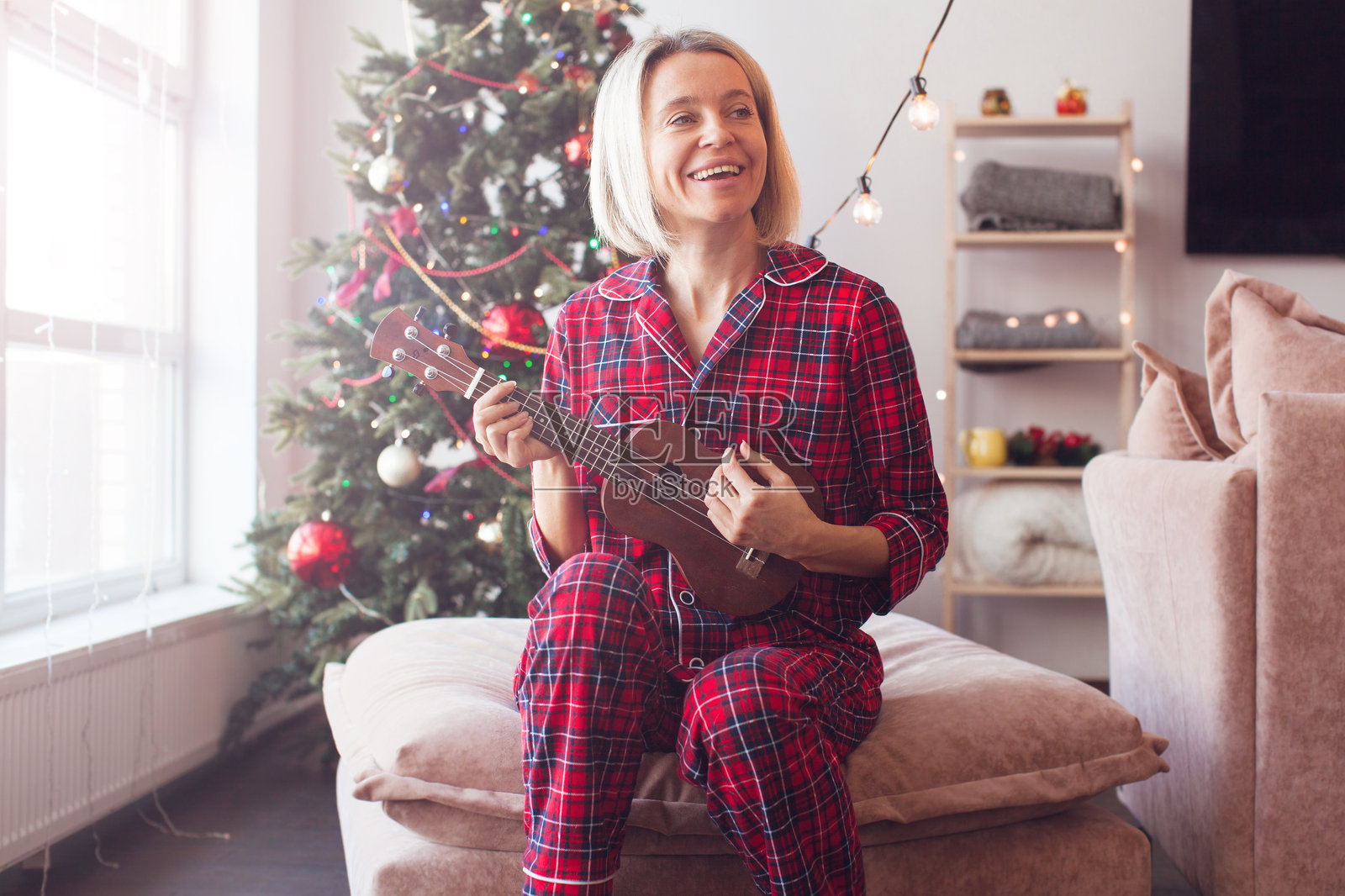 圣诞节、假日和人们的概念 - 快乐的中年女性在弹尤克里里照片摄影图片