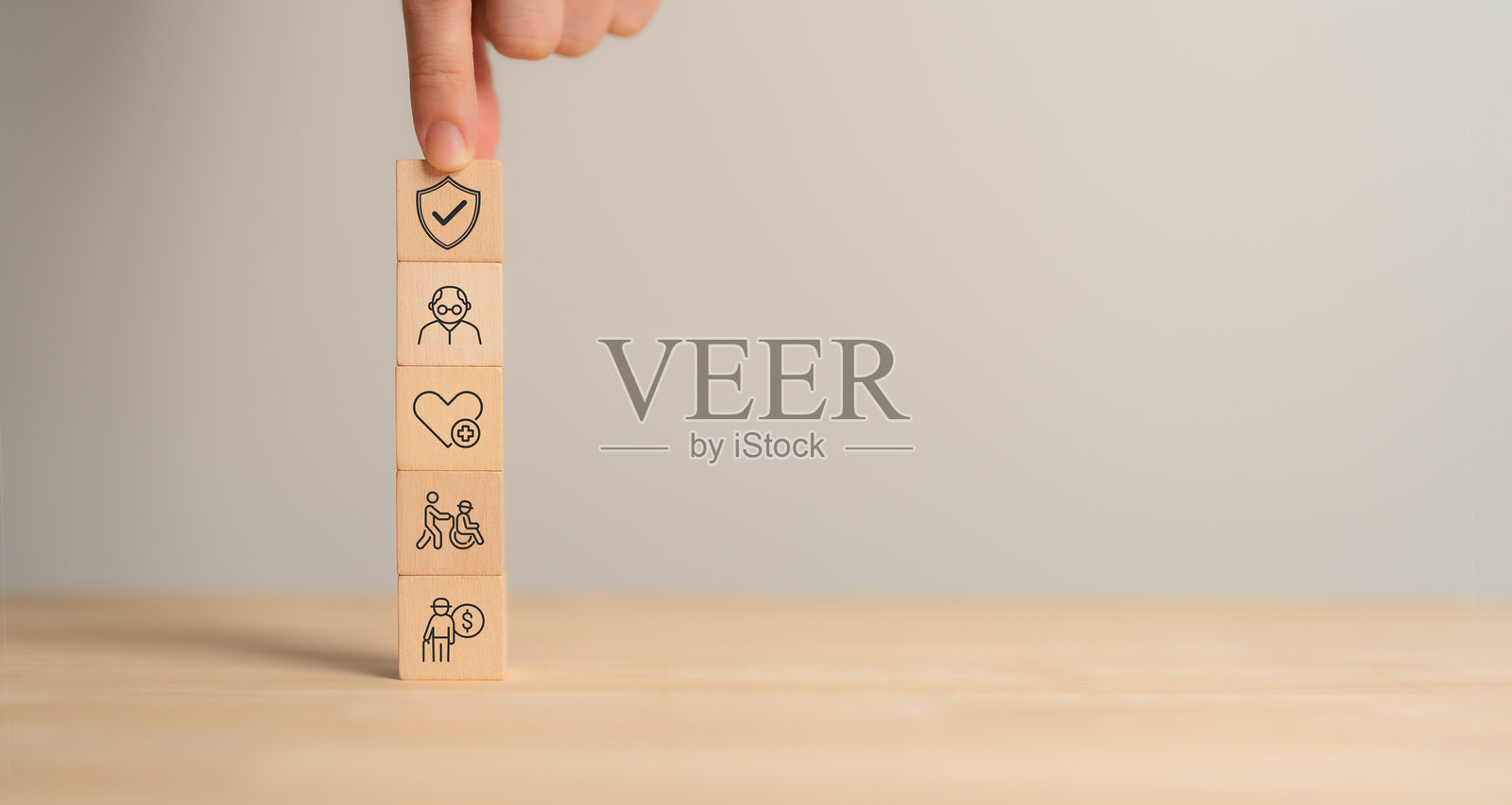 退休规划和保险概念。老年健康保险。一堆木块，代表老年护理、健康、残疾支持以及财务安全和管理。照片摄影图片