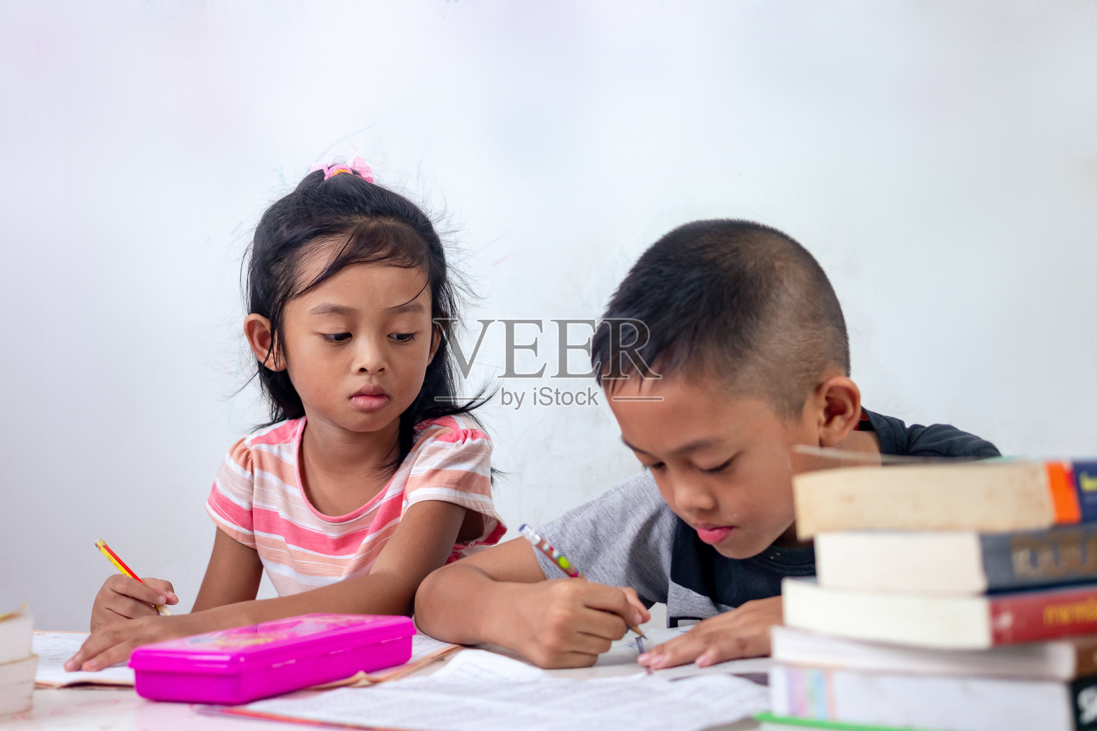 兄弟姐妹们坐在桌子上学习照片摄影图片