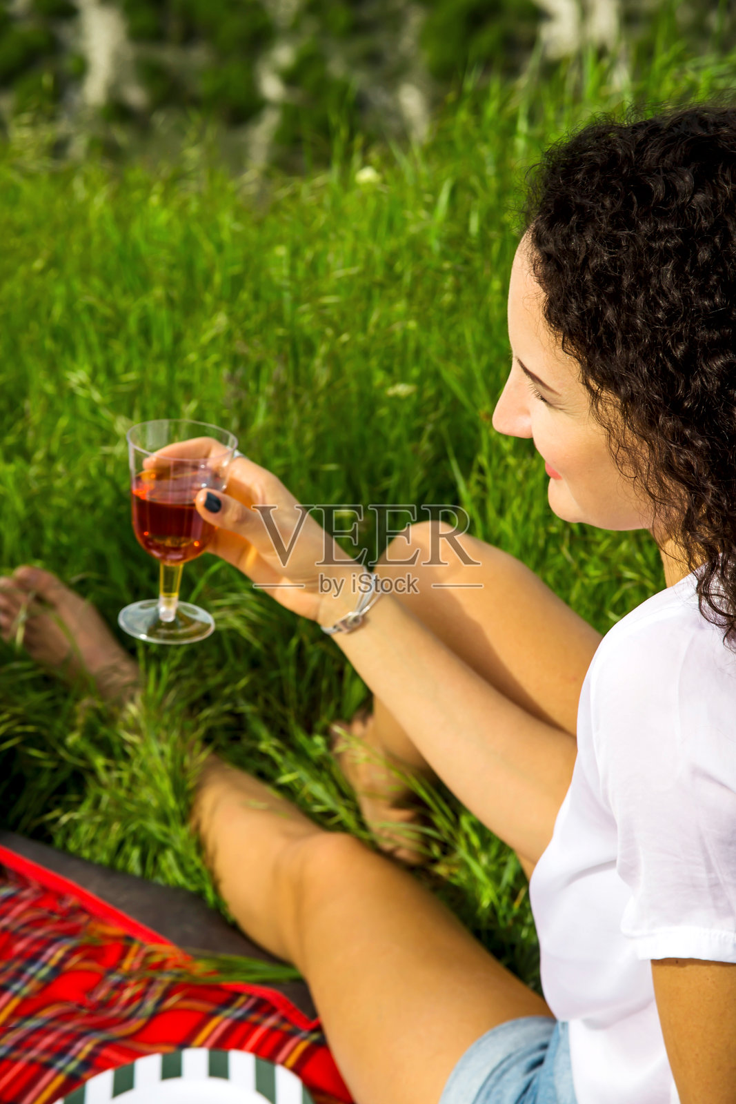 公园里侧面坐着喝饮料的女人照片摄影图片