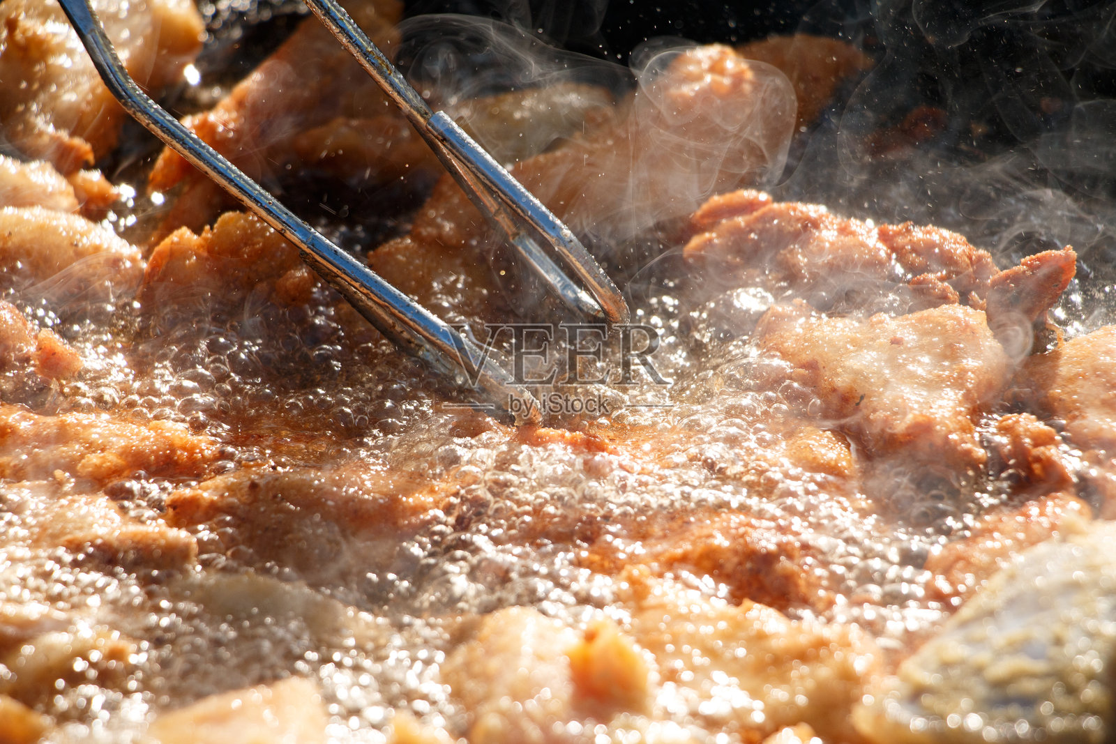 在户外锅中用热油炸鱼皮脆片照片摄影图片