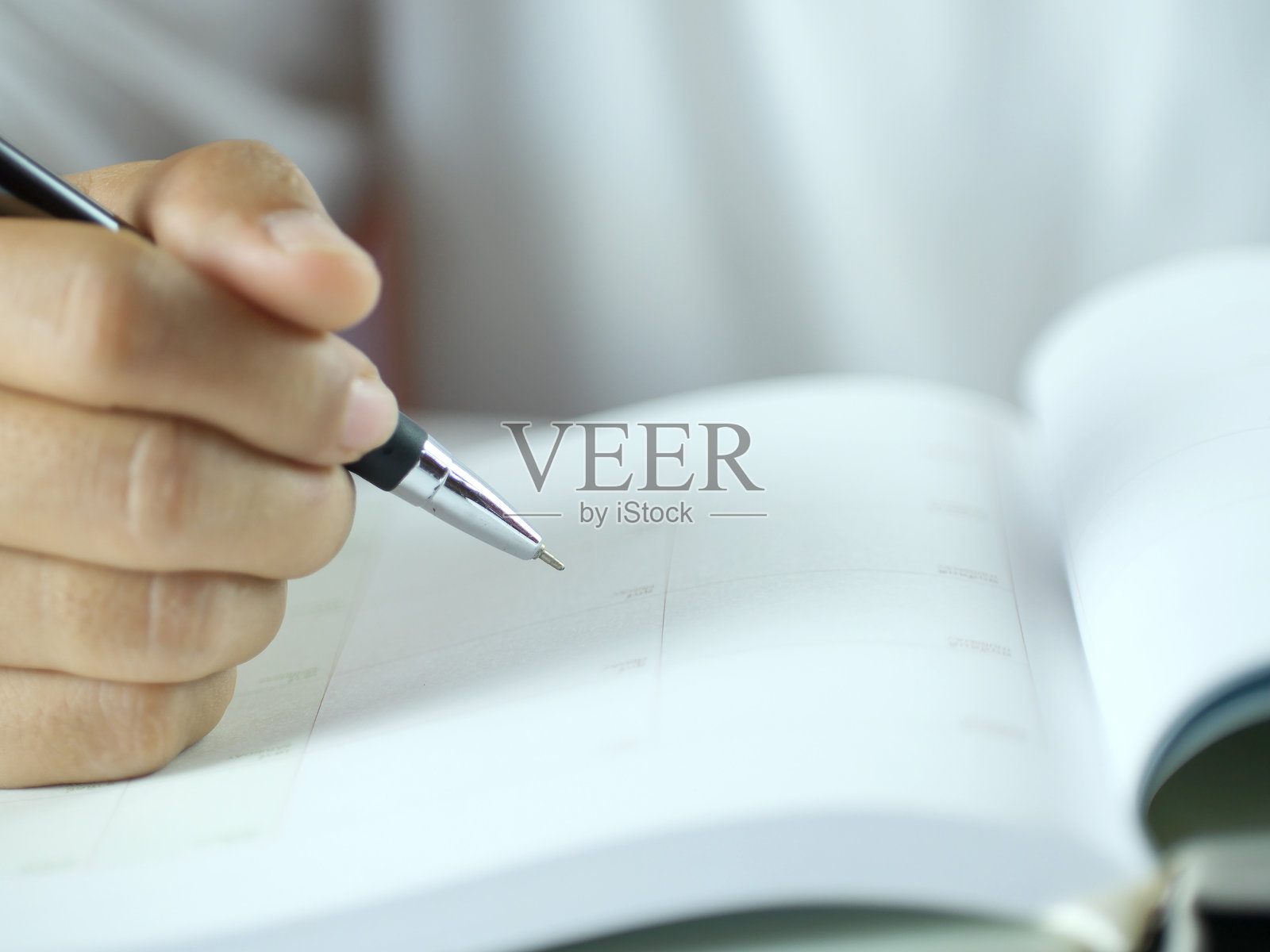 手握钢笔在便签纸上写字。金融商业概念。留白。照片摄影图片