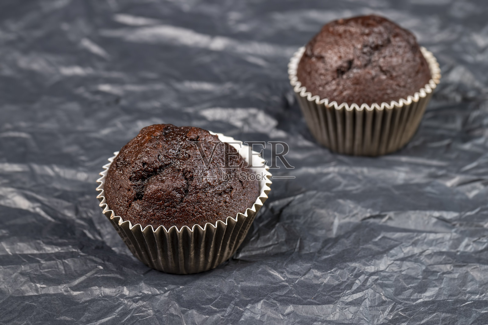 新鲜柔软的黑巧克力杯子蛋糕放在黑色纸上照片摄影图片