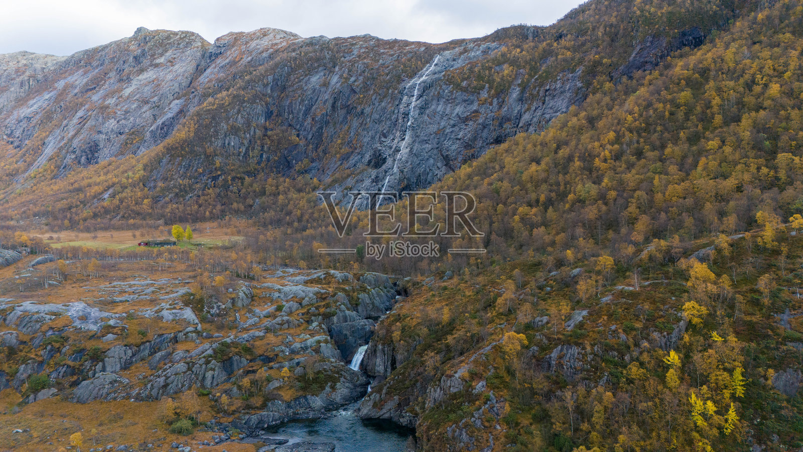 秋天岩石悬崖上的瀑布倾泻而下照片摄影图片