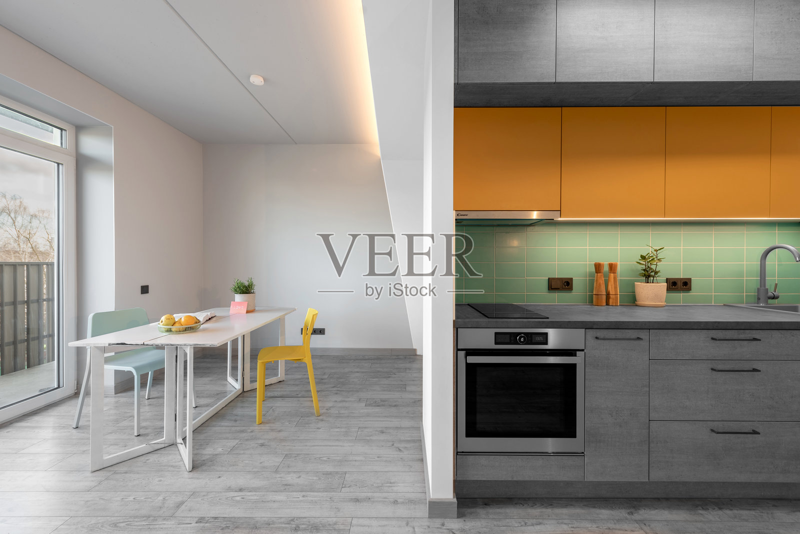 现代厨房室内时尚家具，硬木地板。烤箱、水槽、花卉，极简室内设计。LED灯，硬木地板。白色墙壁。开放空间，餐桌，窗户，花卉。照片摄影图片