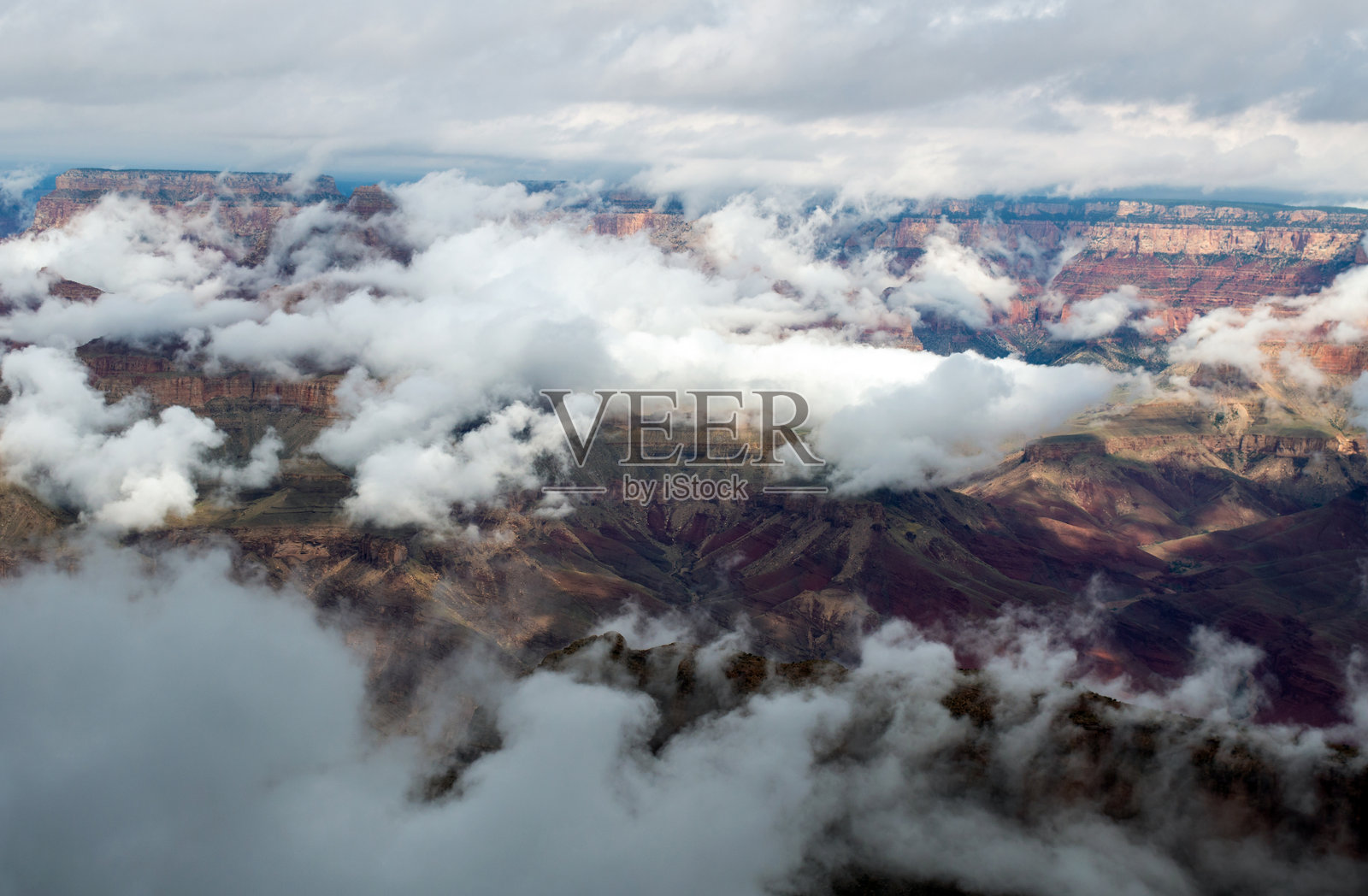 峡谷中弥漫着厚厚的雾气和低垂的云层照片摄影图片