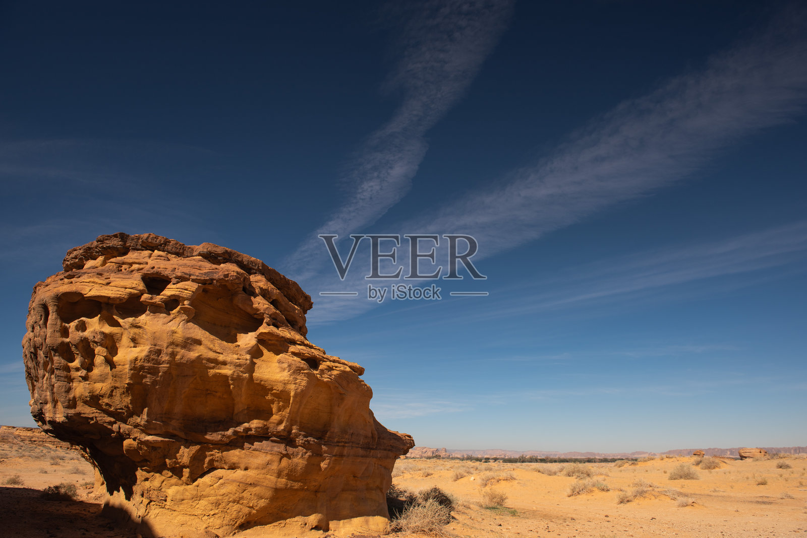 在沙特阿拉伯阿尔乌拉附近的赫格拉，一块看起来像巨大骷髅的岩石与蓝天和云朵相映成趣。照片摄影图片
