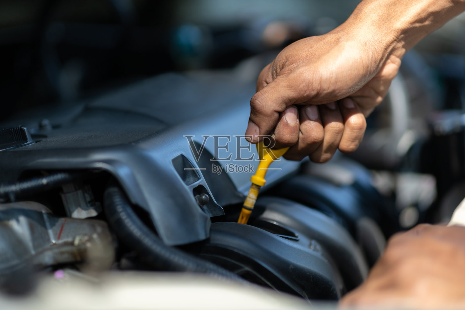 汽车修理工检查发动机和机油。照片摄影图片