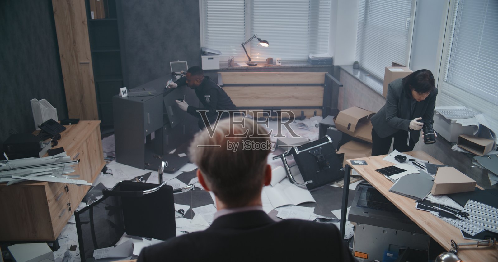 办公室抢劫案：男性侦探背影检查犯罪现场照片摄影图片