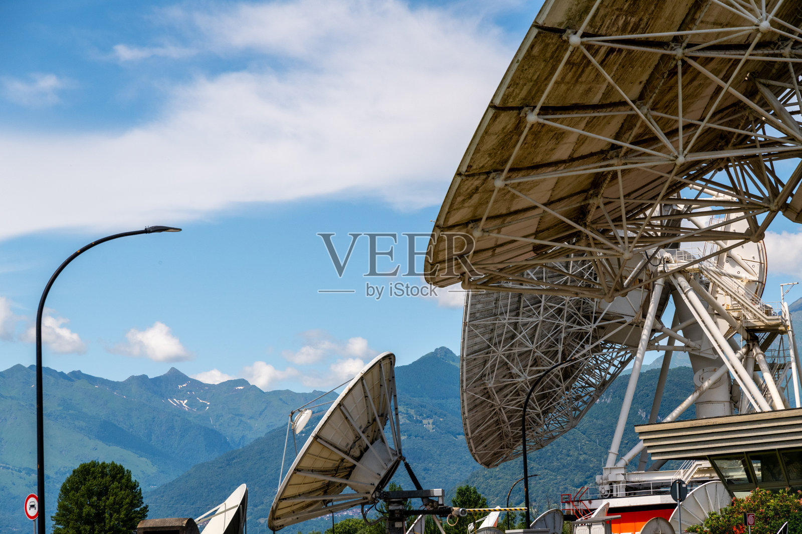 众多大型卫星天线与山脉背景相映衬照片摄影图片