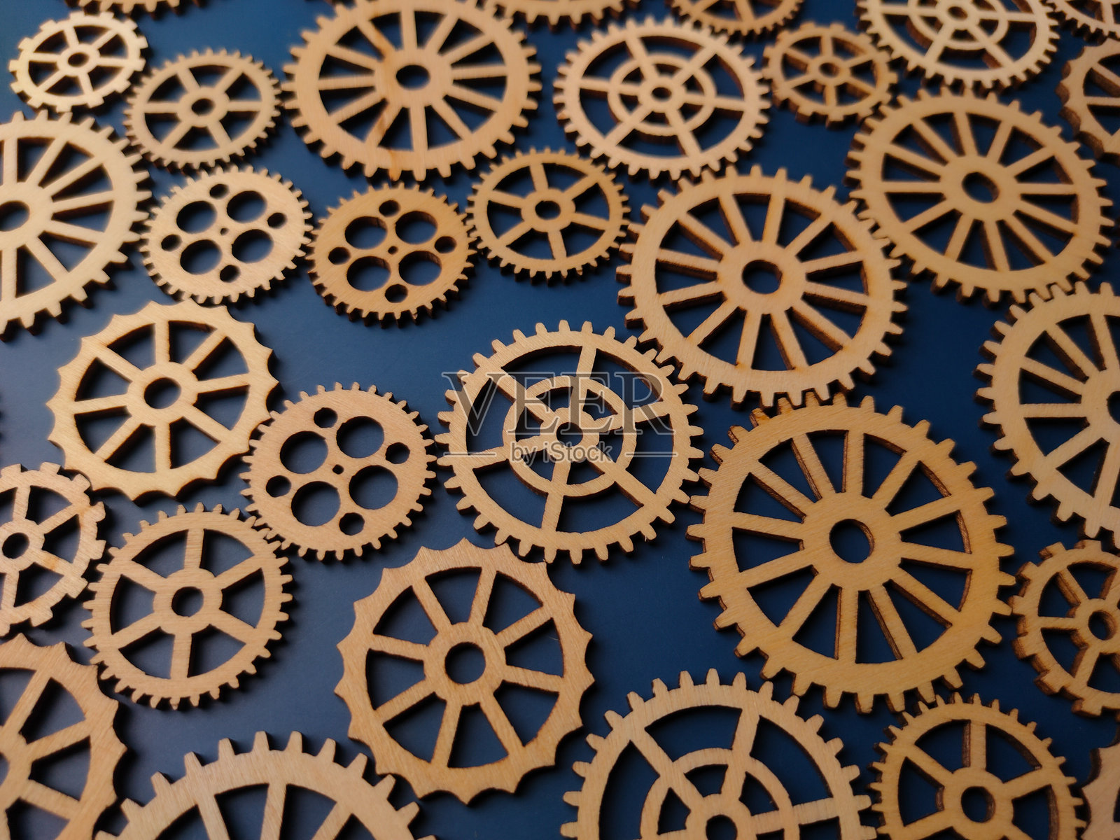 蓝色背景上的木质齿轮特写照片摄影图片