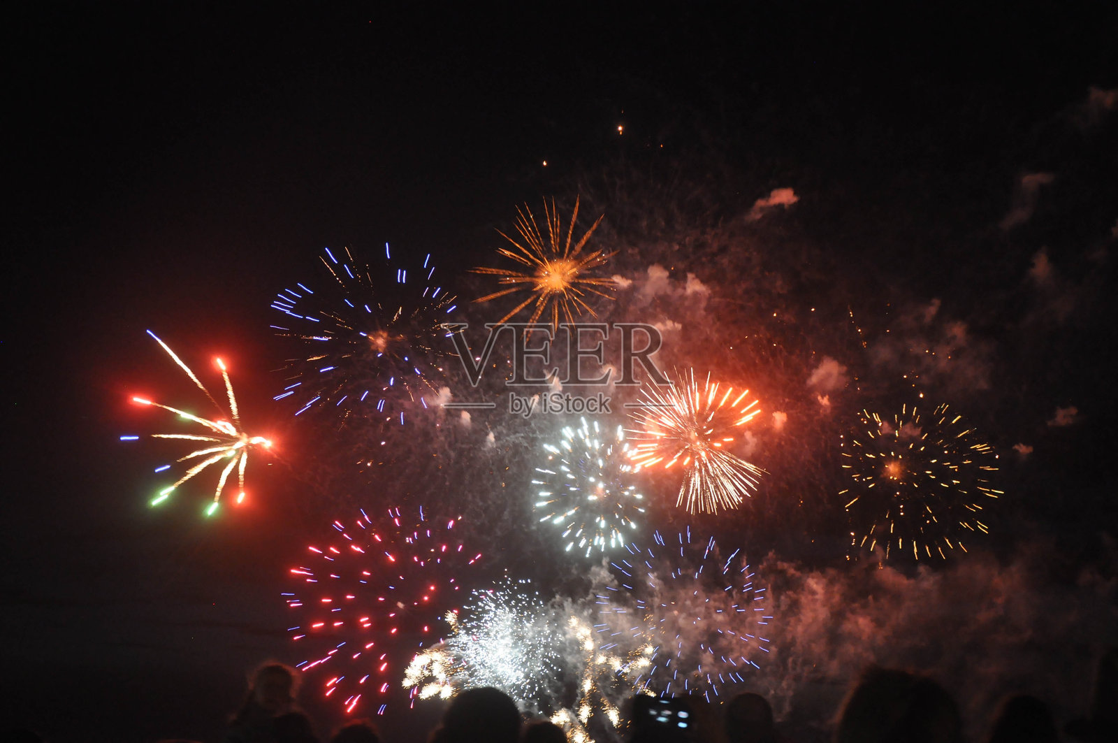 人们反对夜空中的烟花表演照片摄影图片