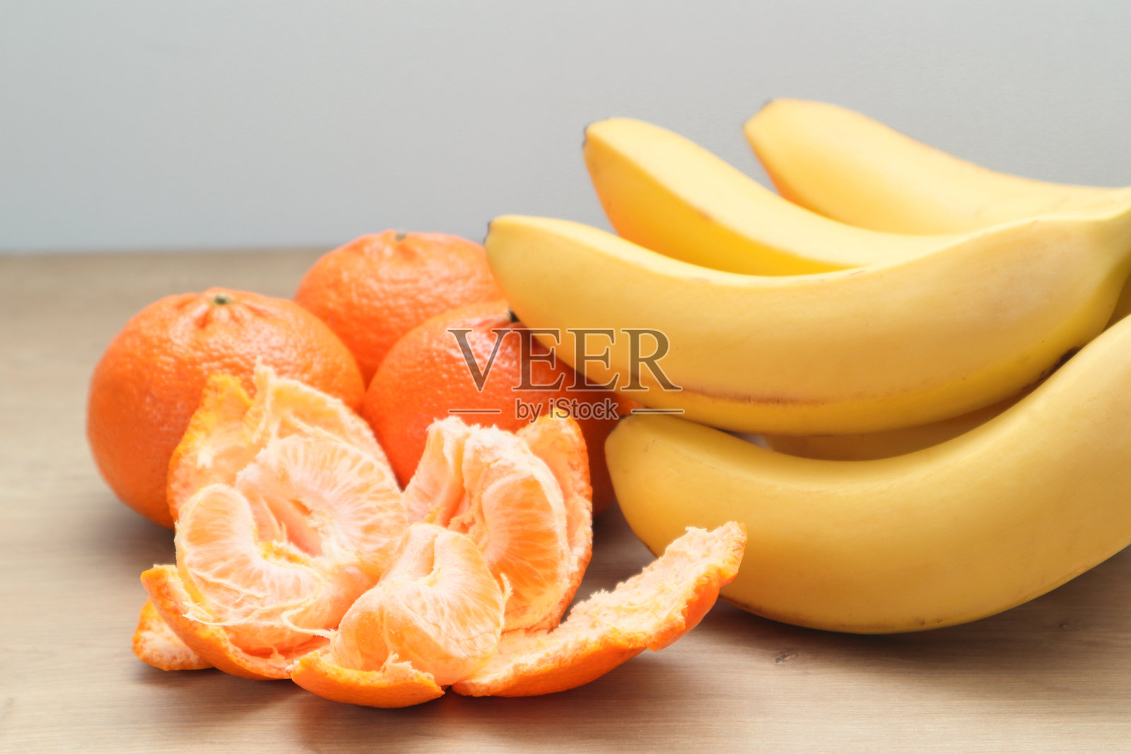水果背景。木桌上的香蕉和橘子。成熟的水果在木桌上。健康水果。素食者、纯素食者和生食者。照片摄影图片