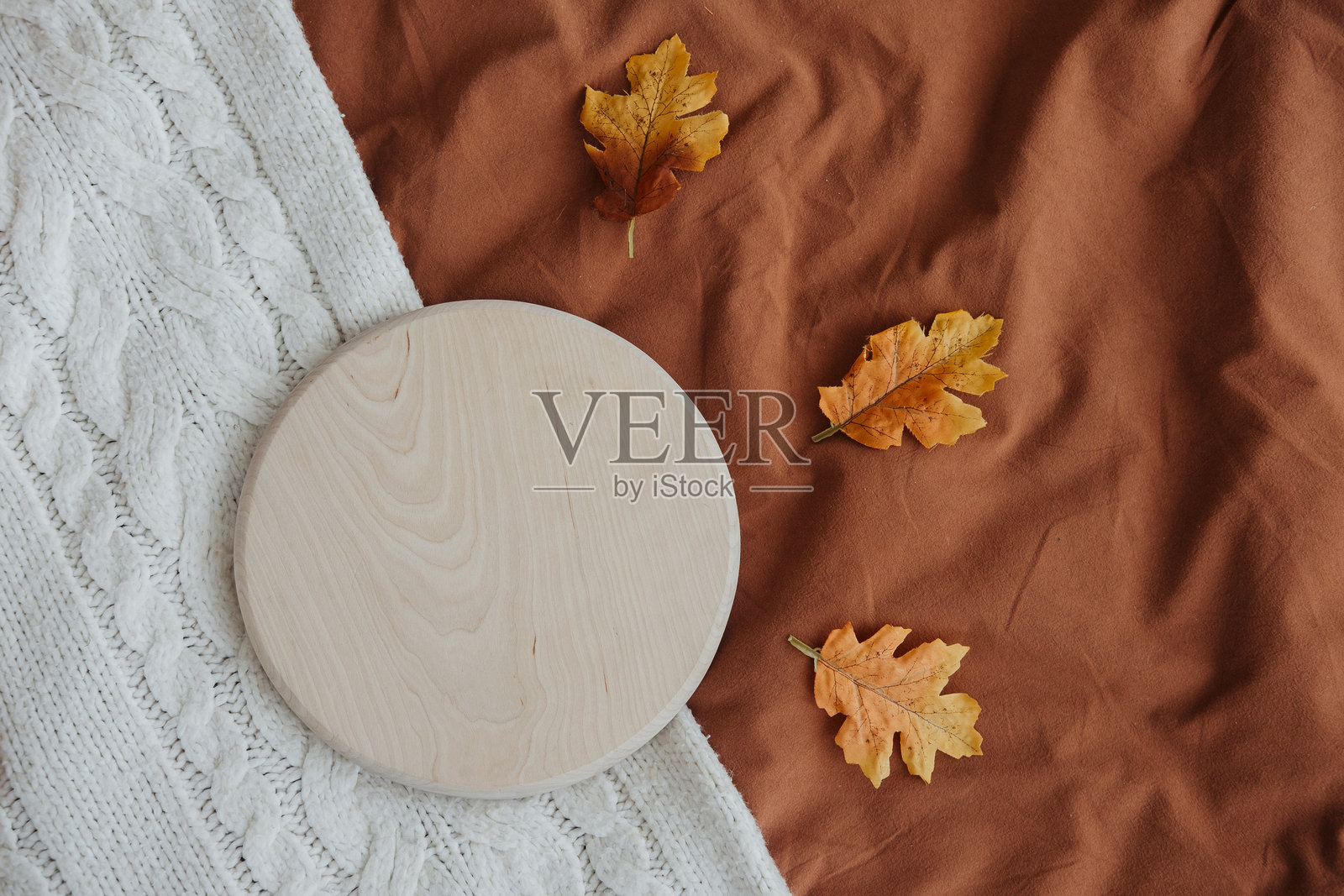 秋天的树叶和木盘在温馨的环境中摆放在有纹理的布料上照片摄影图片