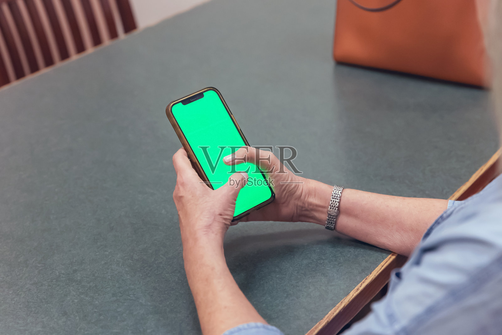 女人手持带有绿色屏幕的手机照片摄影图片