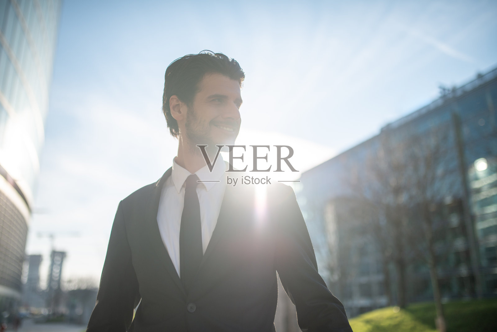 年轻商人在市中心微笑并望向远方照片摄影图片