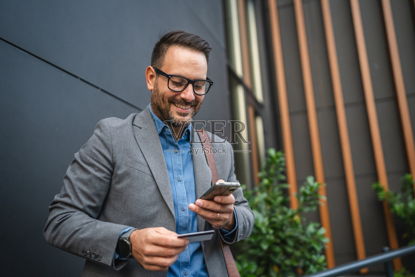 商人使用手机和信用卡进行在线购物照片摄影图片