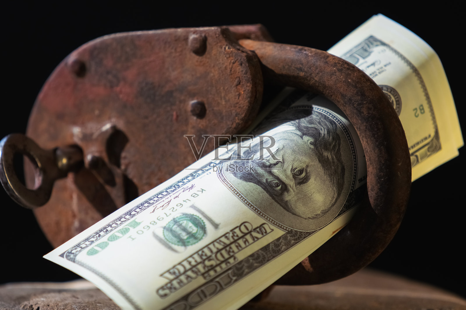 特写镜头展示巨大的金属挂锁和美元捆，象征着投资安全。横向图像。照片摄影图片