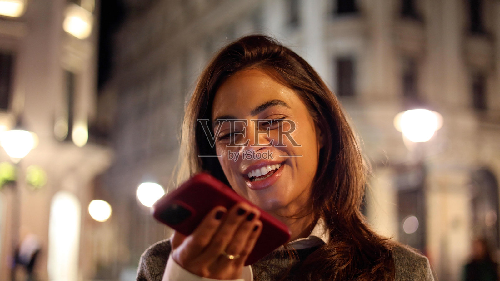 快乐的女人在城市的傍晚享受时光，发送语音消息照片摄影图片