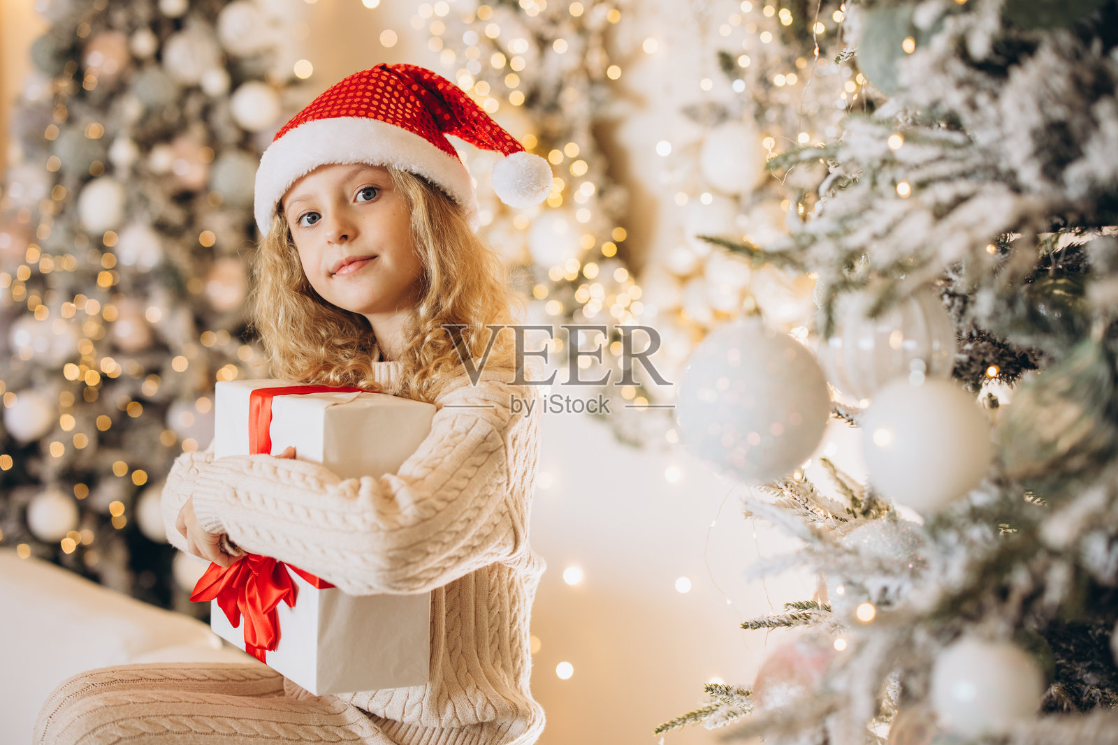快乐的孩子在节日的圣诞氛围中捧着礼物照片摄影图片