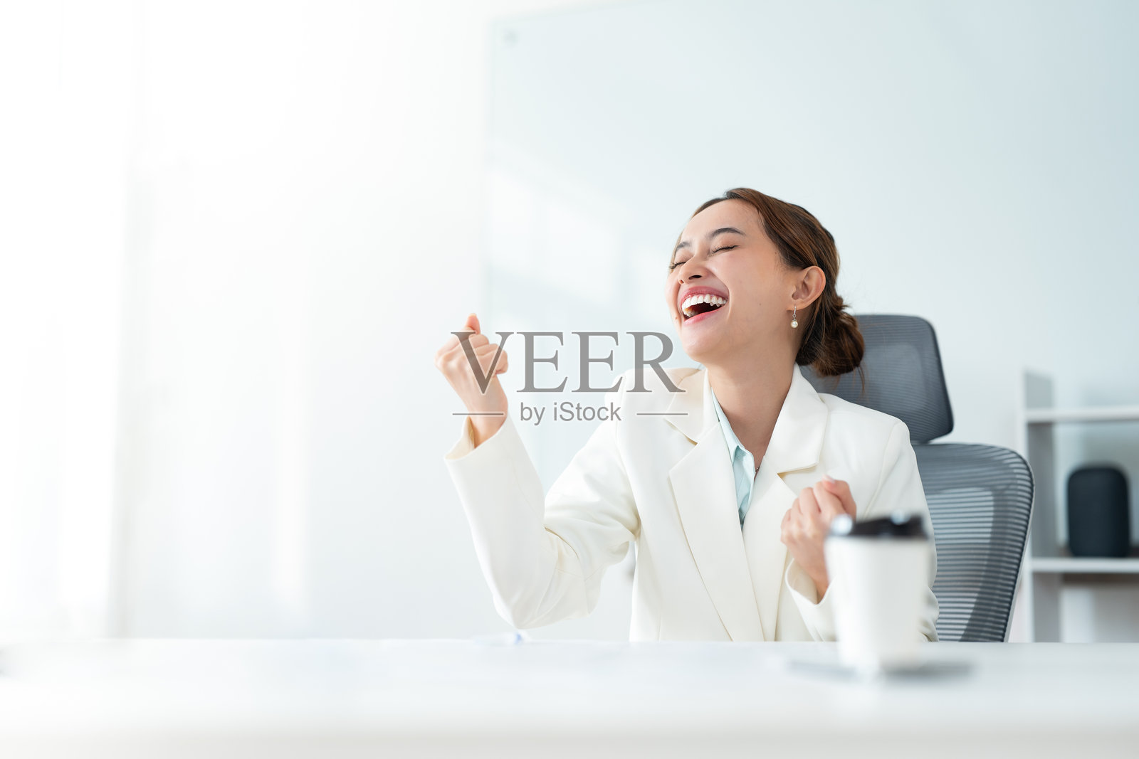 自信的女商人带着快乐的微笑庆祝成功，体现了职业环境中的成就精神照片摄影图片