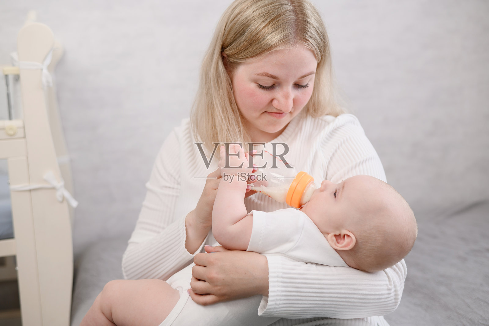 妈妈抱着新生儿，给他喂奶，提供安慰和关爱。照片摄影图片