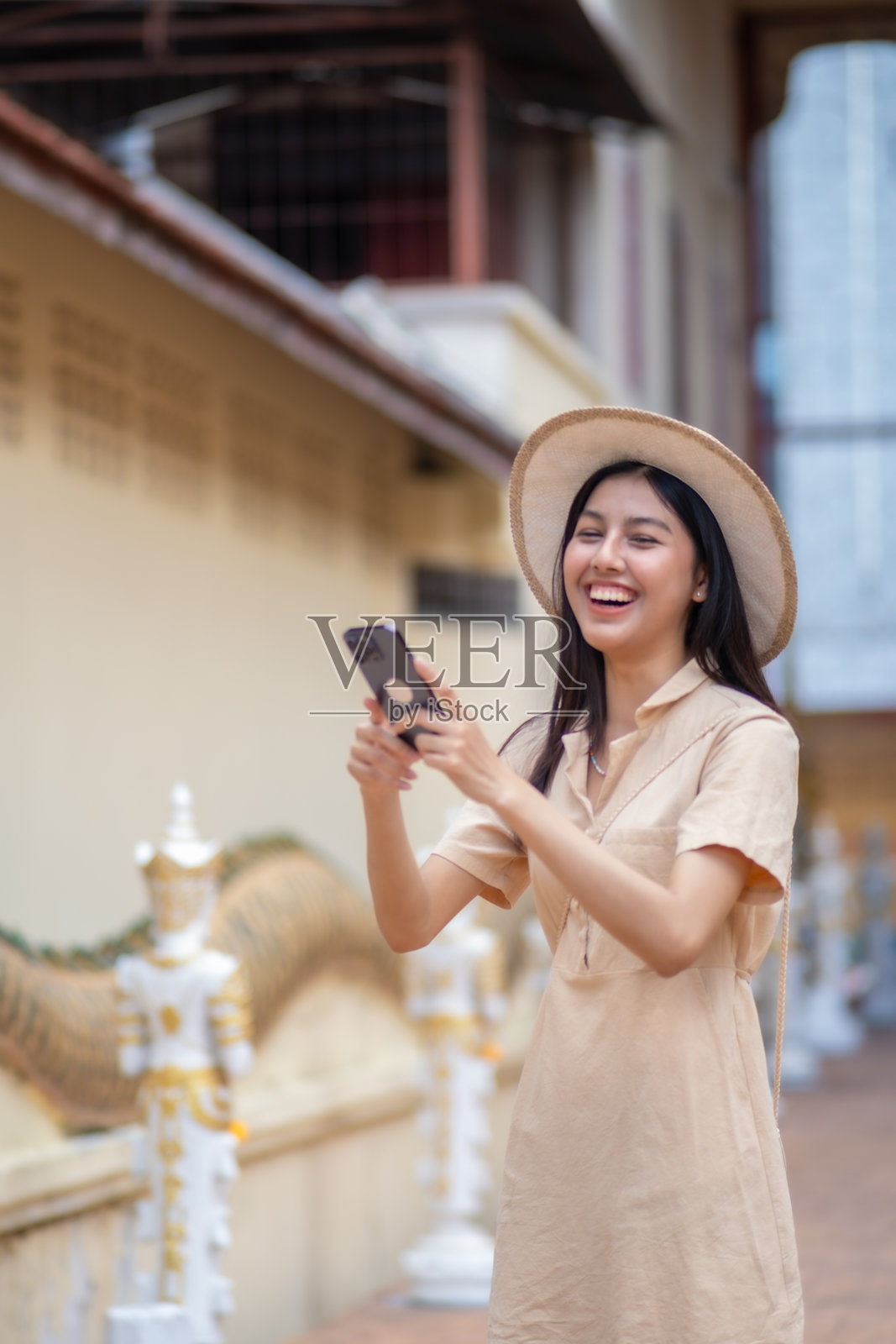 一位女性微笑着用手机拍照照片摄影图片