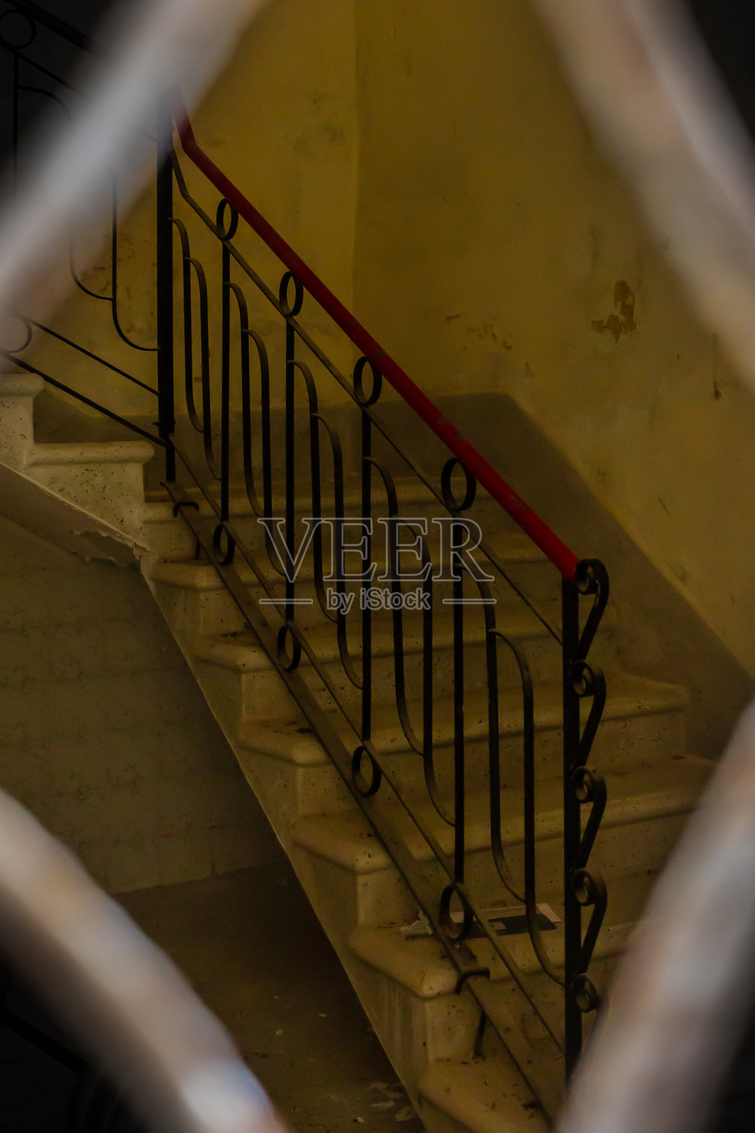 古董楼梯配有华丽的金属扶手，灯光昏暗照片摄影图片