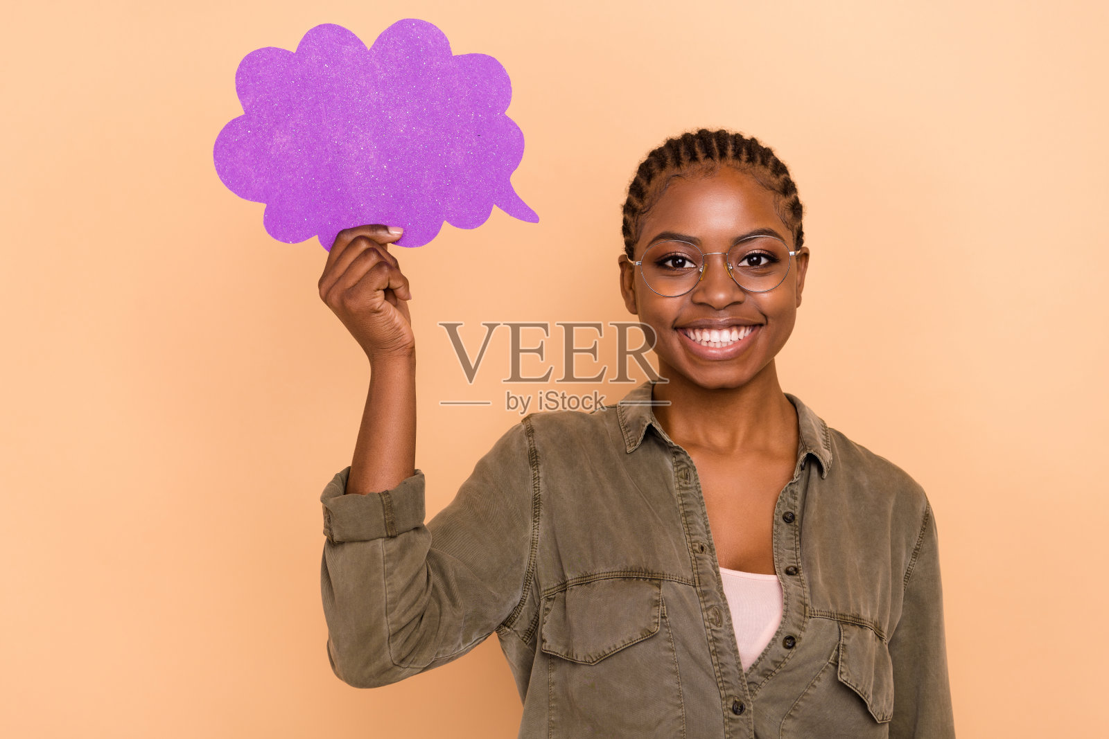 开心的人微笑着手持空白纸云卡片，背景为米色。照片摄影图片