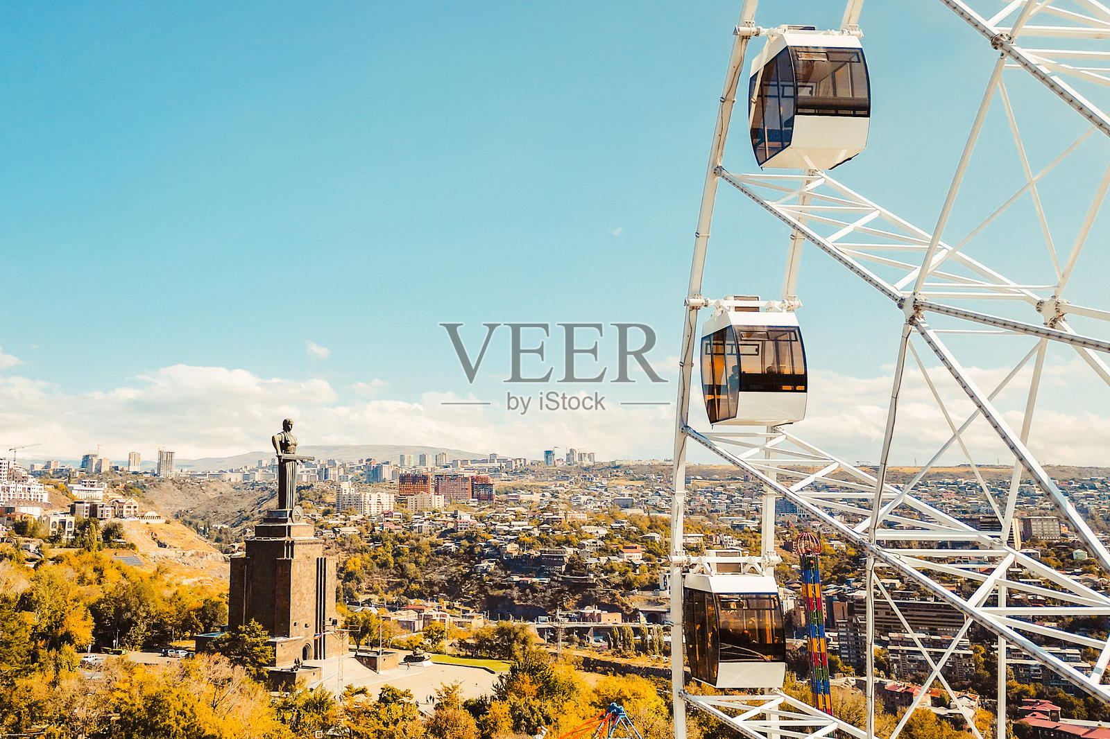 亚美尼亚埃里温 - 2024年10月19日：胜利公园的摩天轮鸟瞰图，背景是埃里温的城市景观和建筑。阳光明媚的秋日，游乐设施，外出活动的概念。照片摄影图片