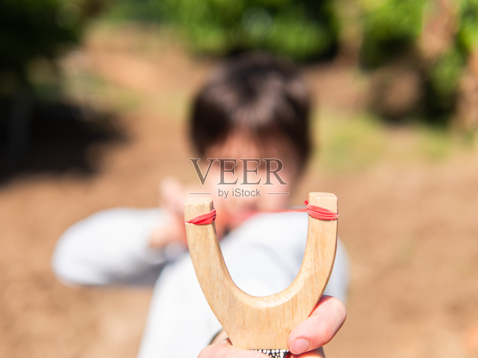 聚焦于户外瞄准弹弓的孩子照片摄影图片