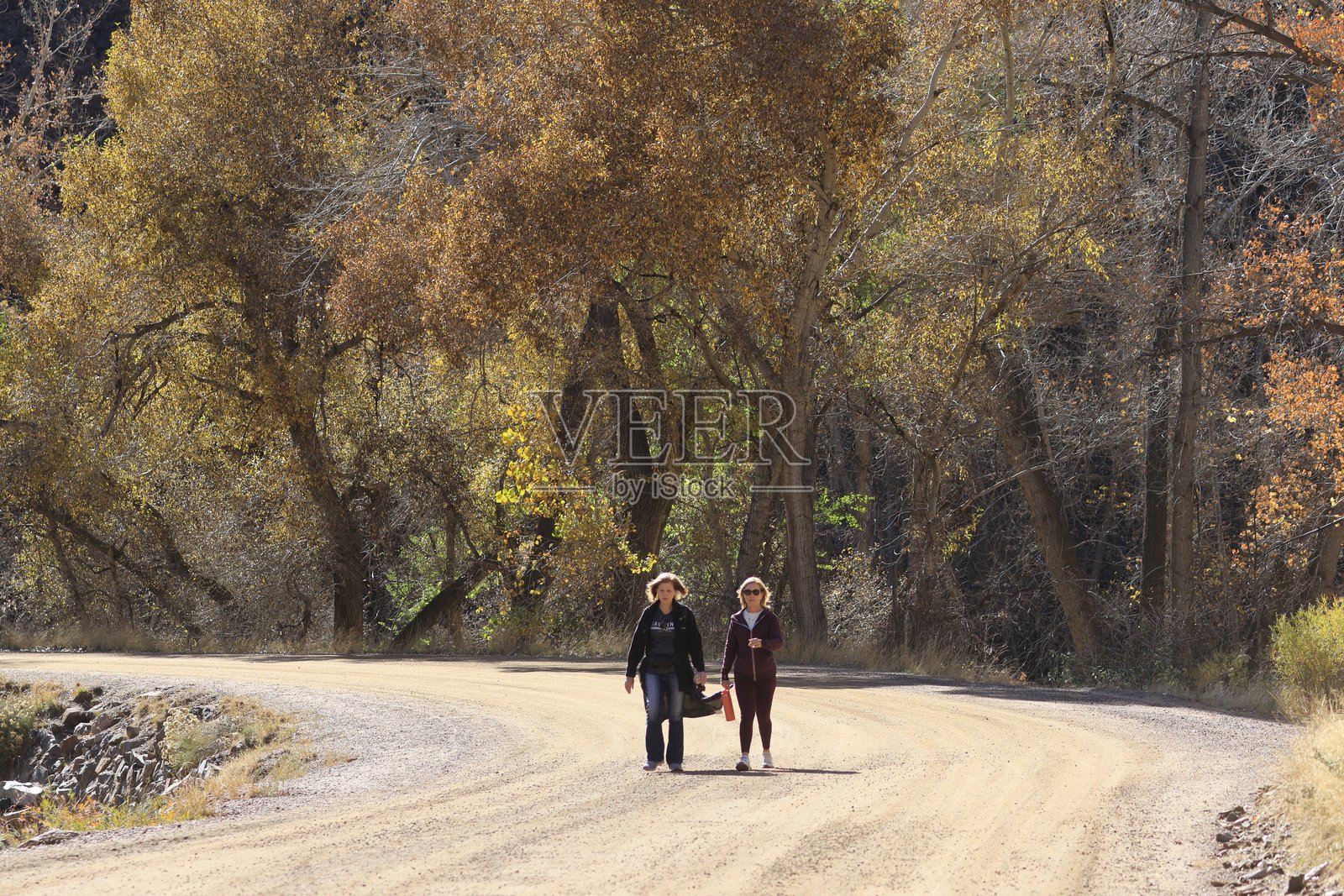 秋天的女人在泥土小路上行走照片摄影图片