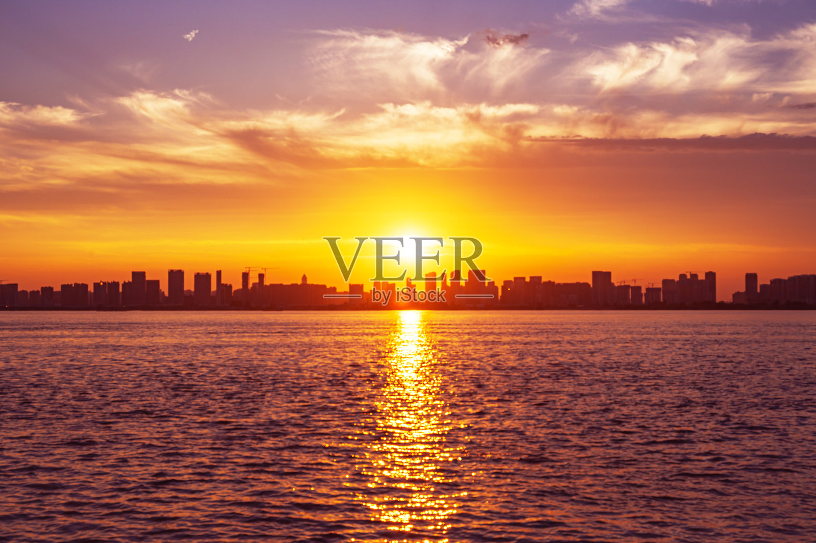 戏剧性的天空和云彩与现代城市天际线在日落时的虚焦模糊抽象背景照片摄影图片