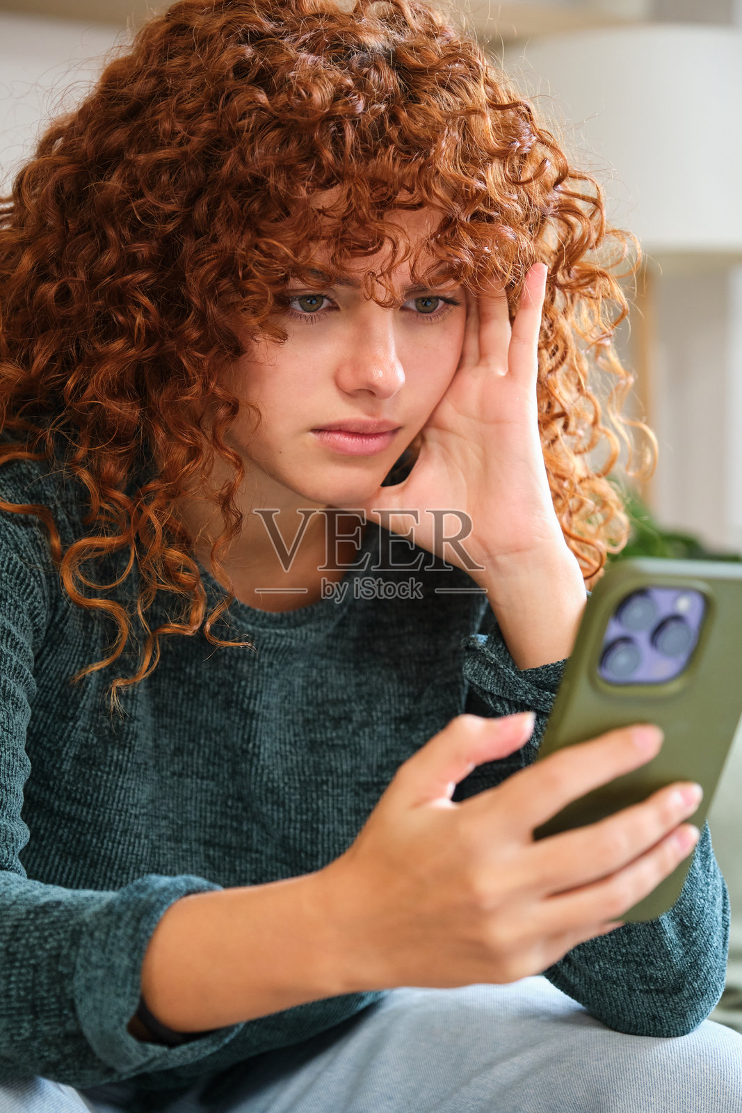 年轻女性在家中用手机阅读坏消息照片摄影图片