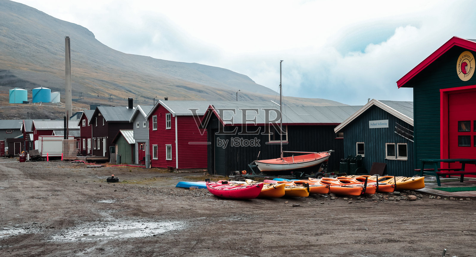色彩鲜艳的皮划艇停靠在长年岛木建筑旁边的崎岖小径上照片摄影图片