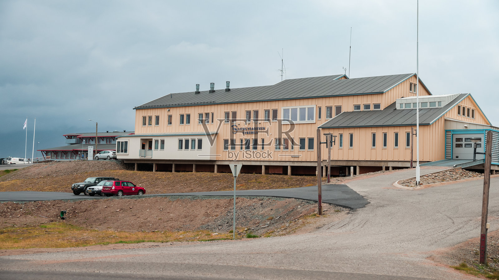 长年岛斯瓦尔巴特的木制建筑,背景是多云的山脉。照片摄影图片