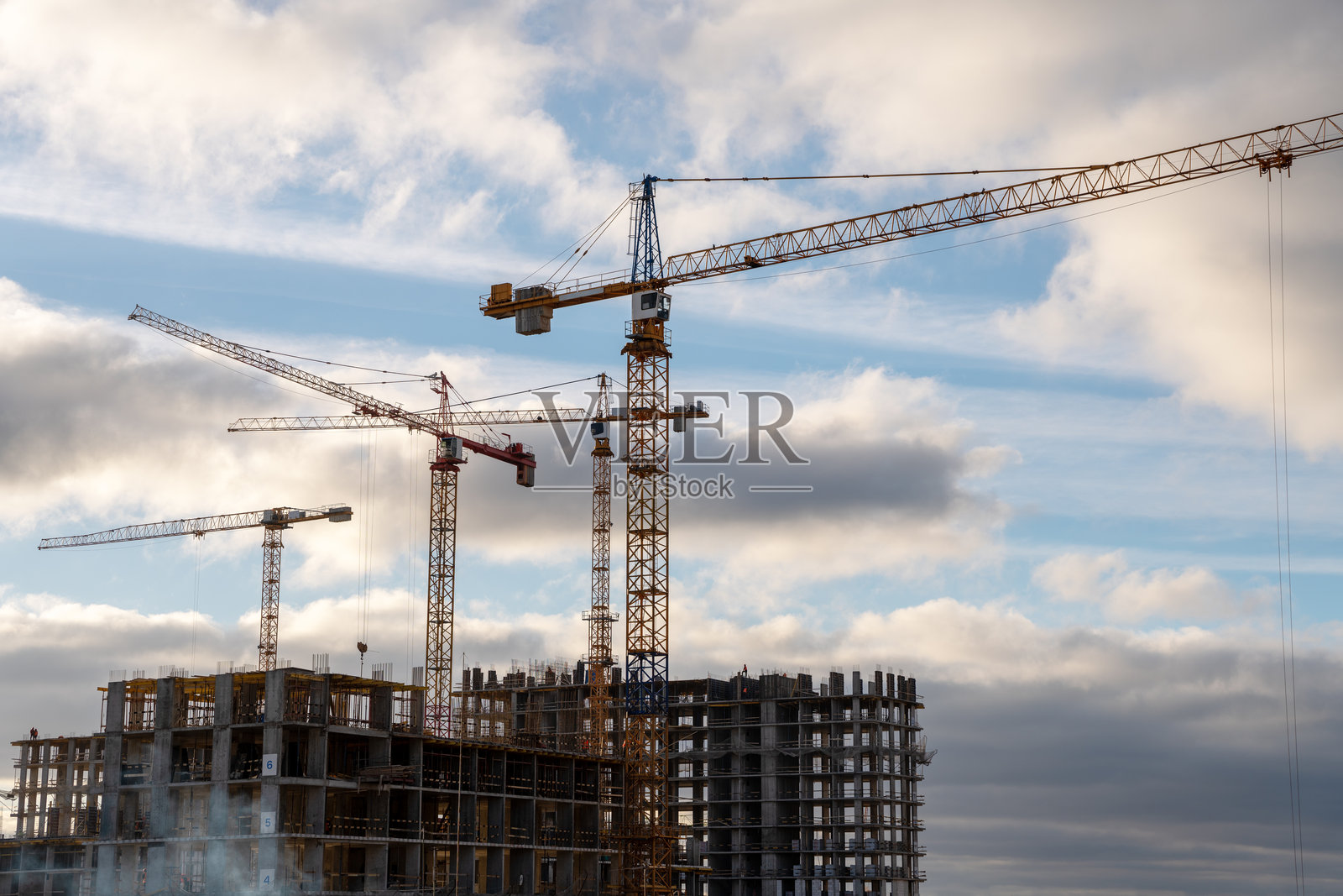 建筑工地上塔吊与戏剧性的天空照片摄影图片