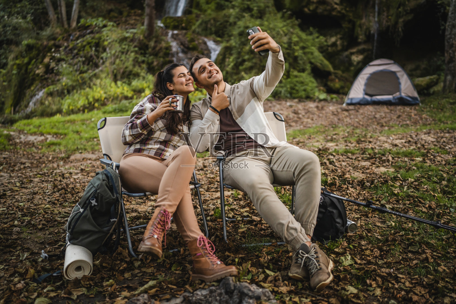 一对情侣坐在森林中的帐篷前拍摄自拍照照片摄影图片
