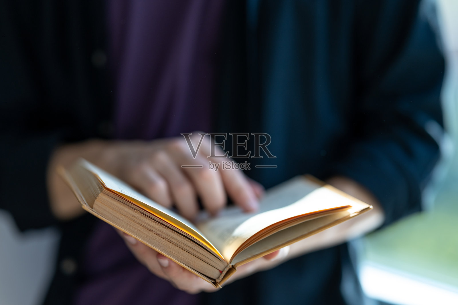 一个陌生男子手持书籍专心阅读的特写镜头照片摄影图片