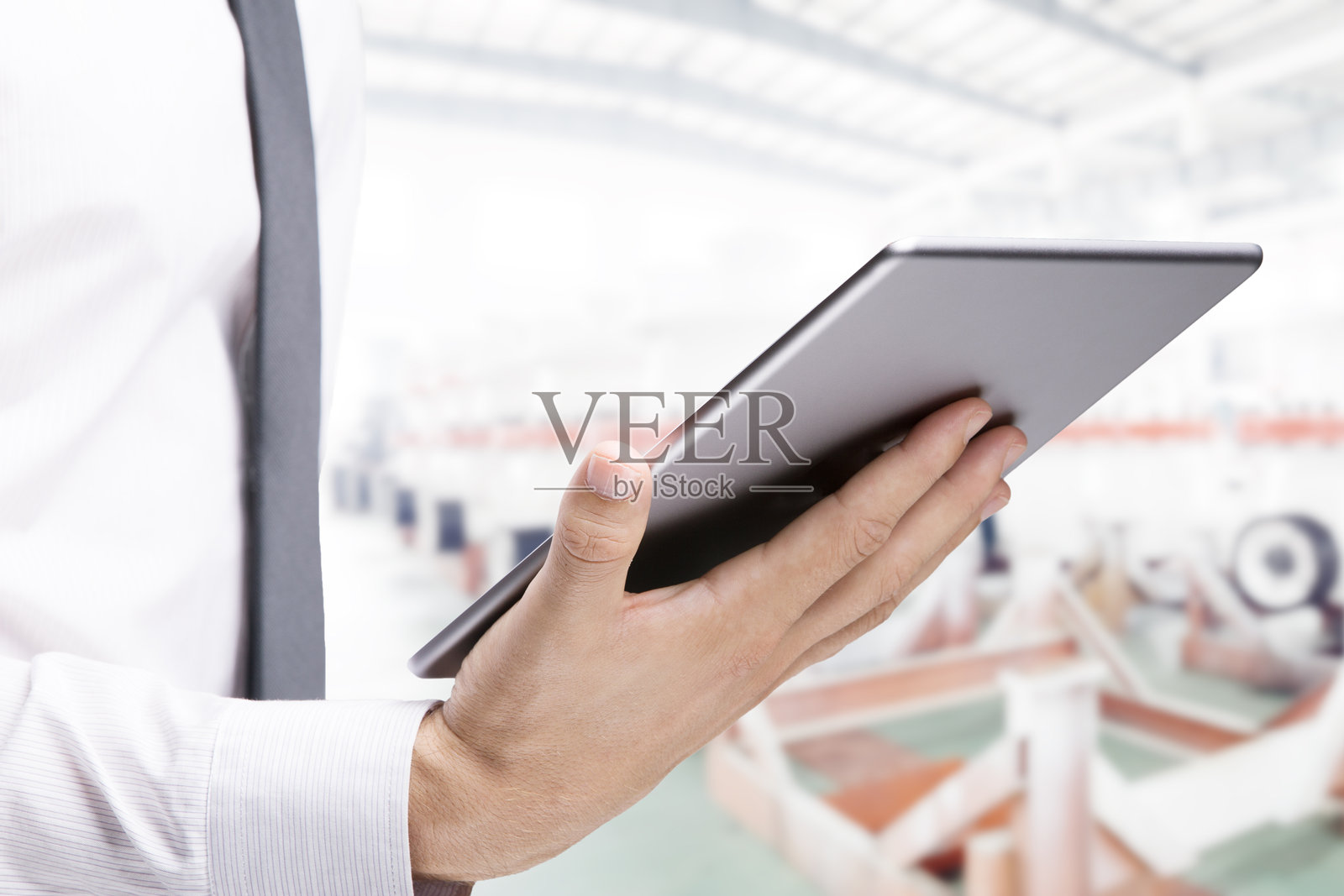 商务人士手拿平板电脑在车间里工作照片摄影图片