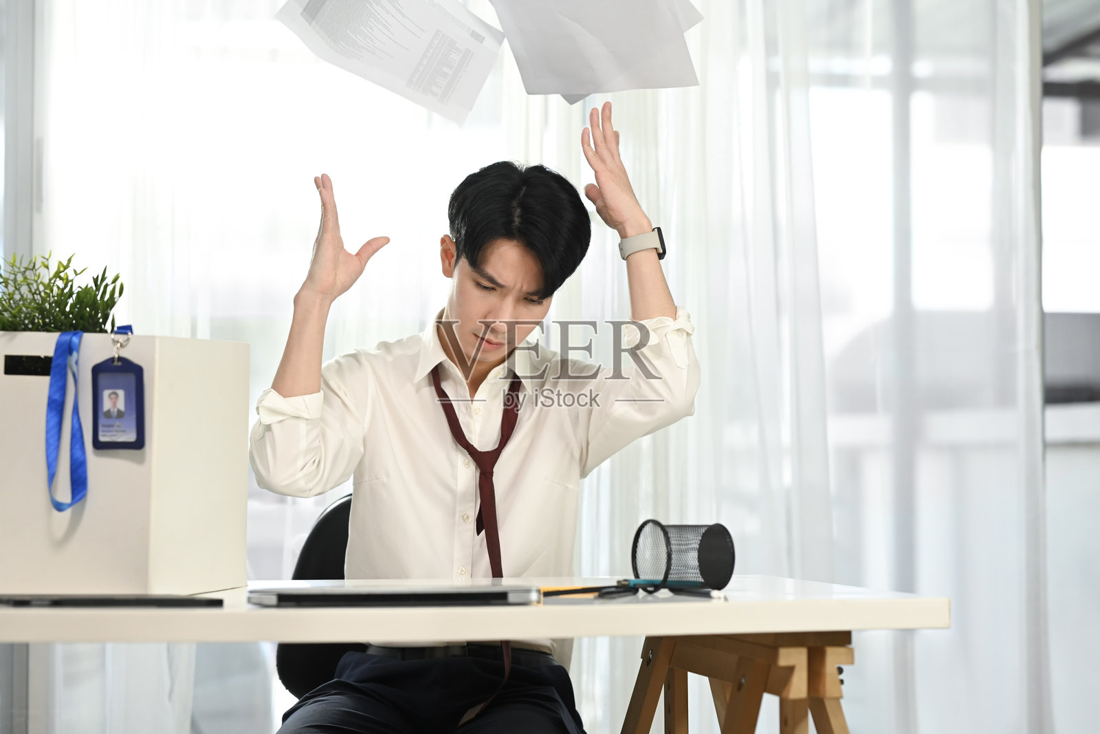 沮丧的办公室工作人员愤怒地扔掉文件。工作压力的概念照片摄影图片