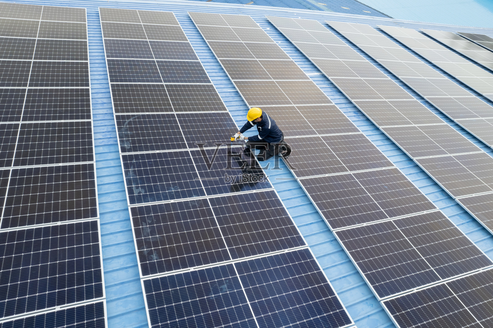 工程师在工厂屋顶检查太阳能电池板照片摄影图片