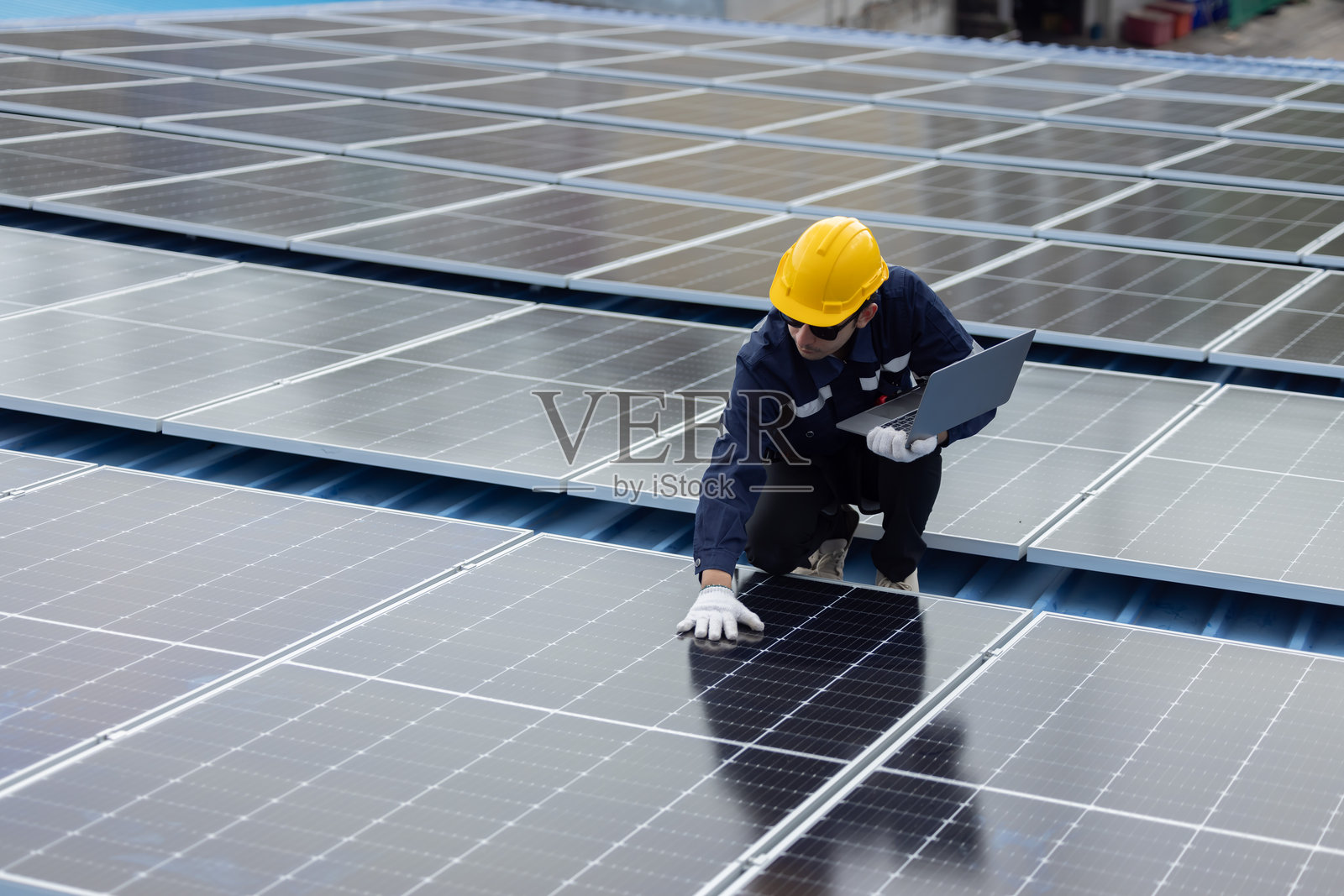 工程师在屋顶检查太阳能电池板照片摄影图片