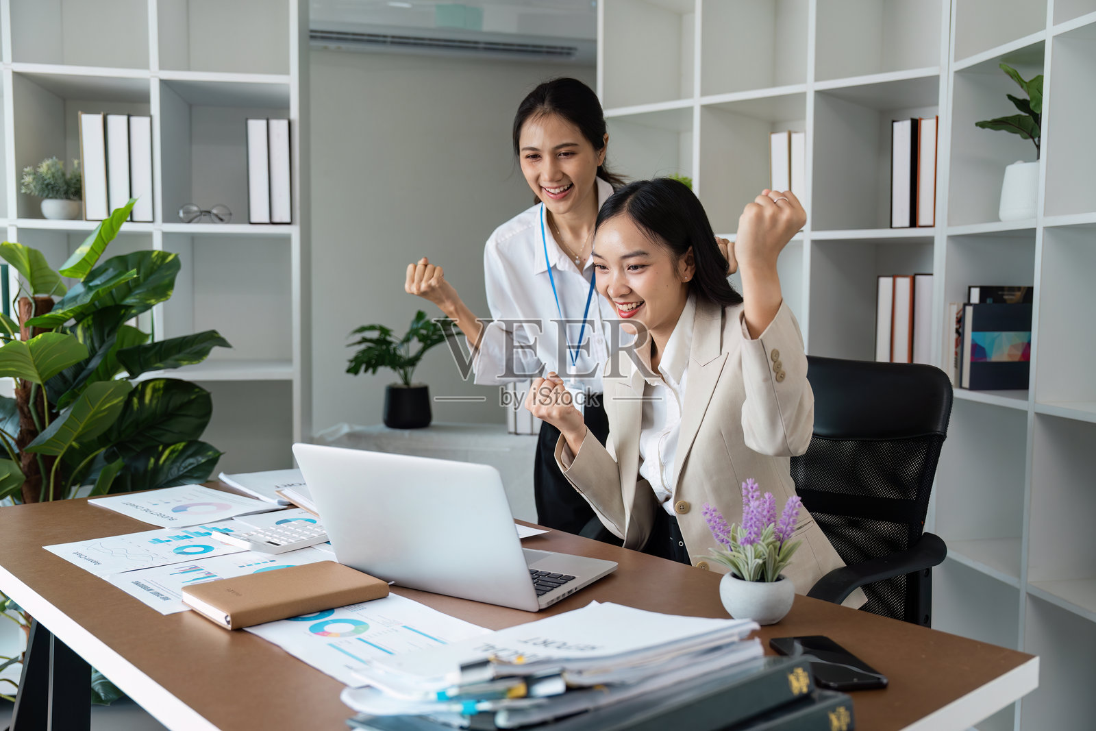 现代办公室环境中，充满活力的商业团队庆祝成功，展现科技与创新。照片摄影图片