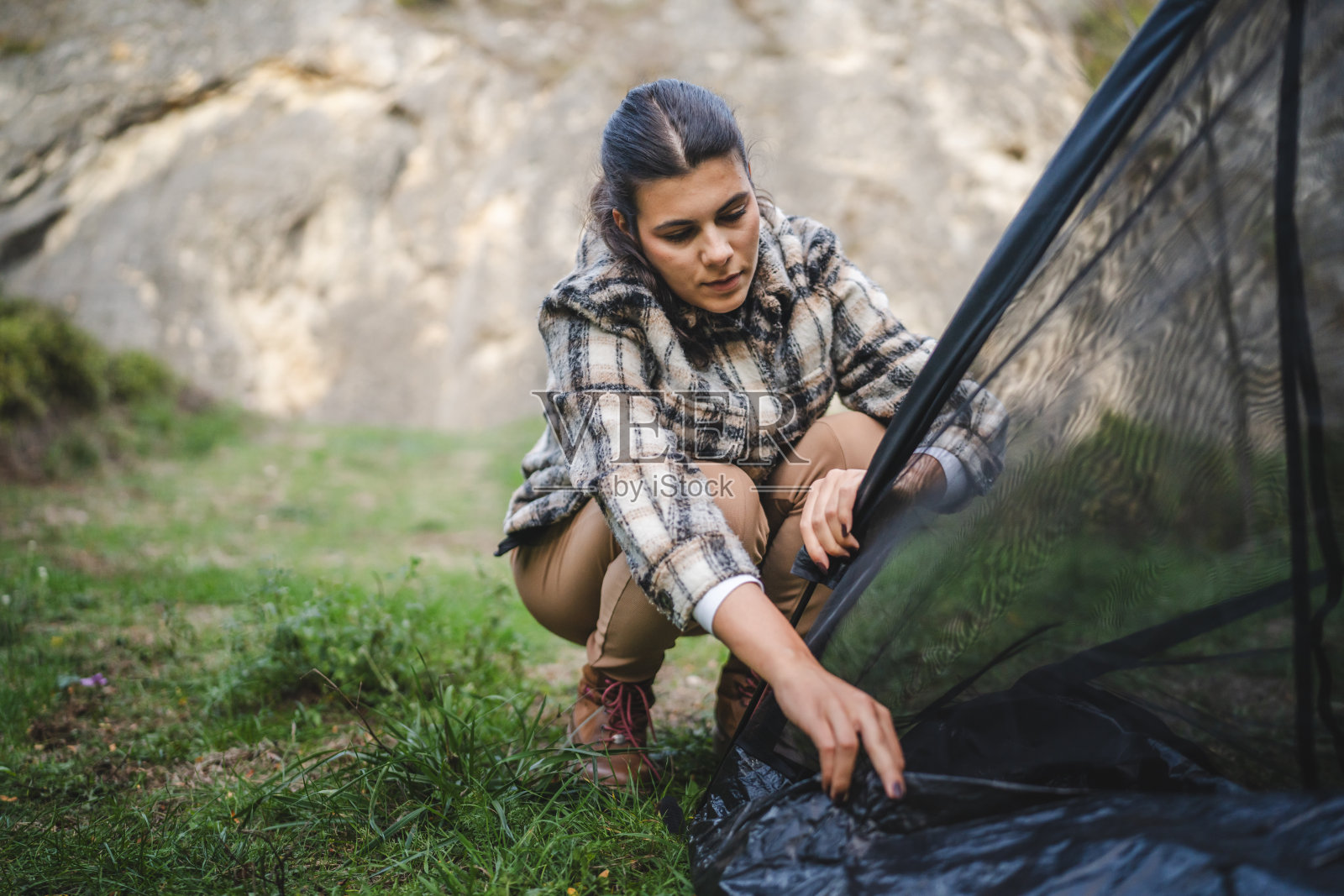 成年女性在宁静的山地风景中搭建帐篷照片摄影图片