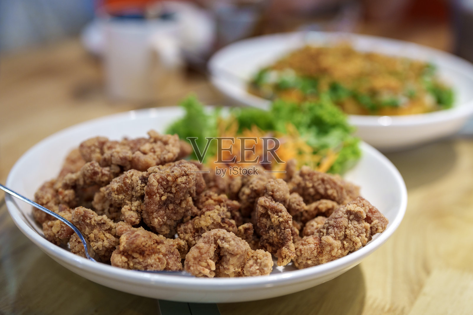 白碗中盛着脆皮炸鸡，配以新鲜的装饰照片摄影图片