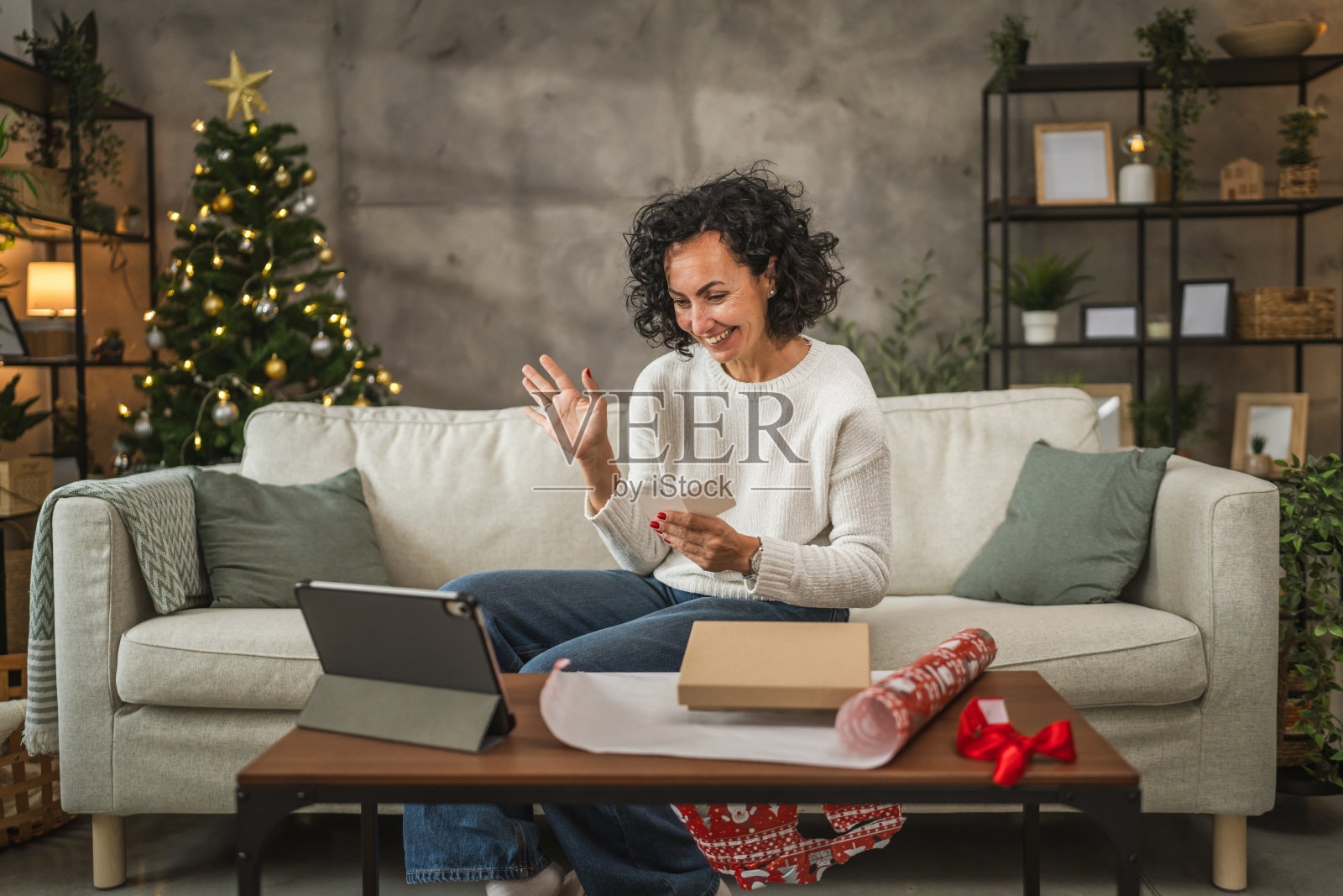 成熟的女性通过视频通话阅读圣诞礼物的贺卡照片摄影图片