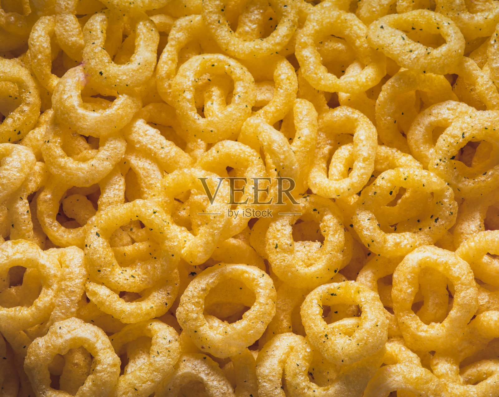 白色背景上的咸味小吃碗。前景中有薯条、爆米花、培根片、洋葱圈、饼干和椒盐卷饼。照片摄影图片