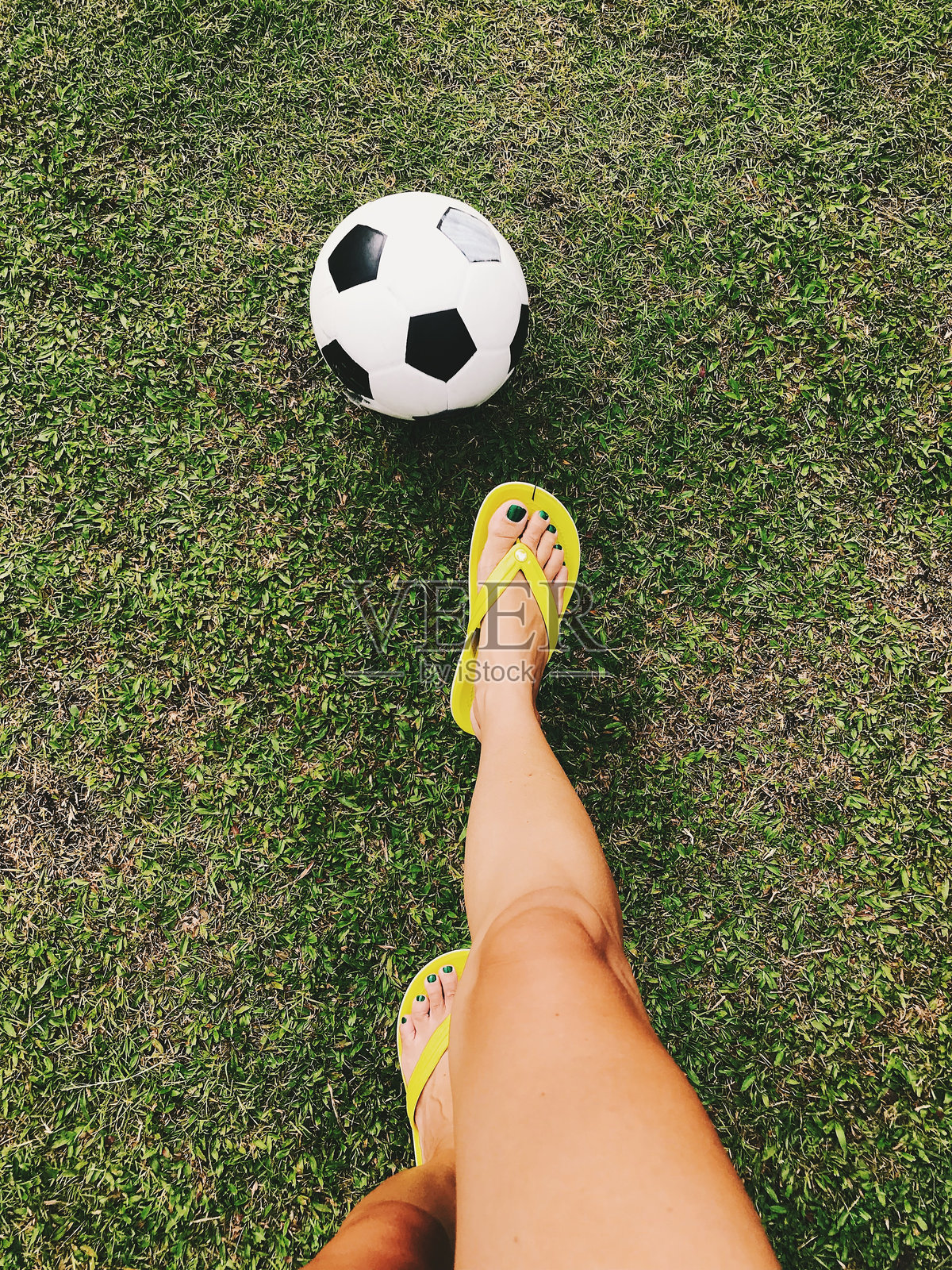 女性在球场上踢足球的下半身照片摄影图片