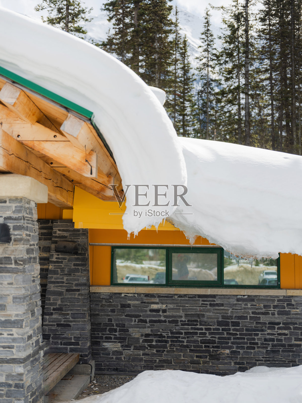 森林中小屋屋顶上的厚厚积雪照片摄影图片